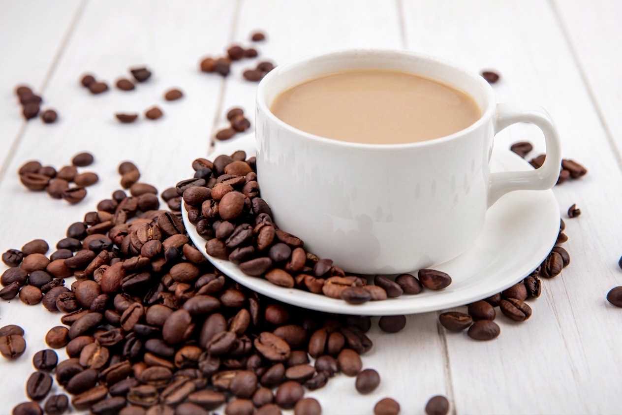 Side view of coffee on a white cup with coffee beans