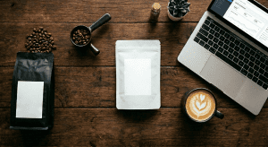coffee beans in package, blank label package and a laptop showing business plan